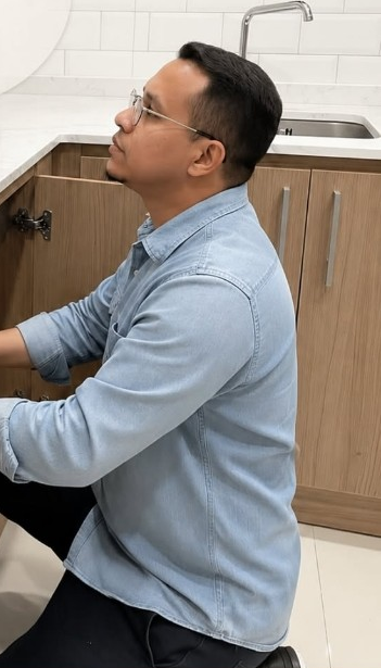 Profissional da S.O.S trabalhando na hidráulica de uma cozinha